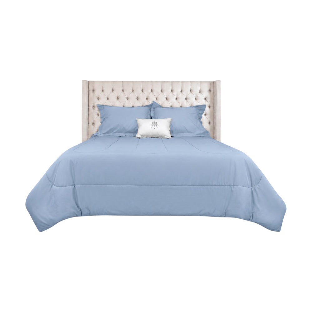 Edredón ARLIN color celeste de 150 hilos, mezcla de algodón y poliéster, con fundas a juego sobre cama capitoné.