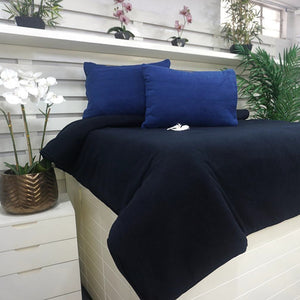 Funda duvet ARLIN de tela polar azul marino, suave y térmica, sobre cama con almohadas a juego en dormitorio moderno.